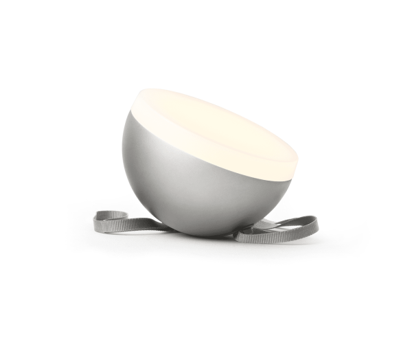 ET NYT VÆRK - Sphere Adventure Lampe vippede lidt fremad, hvilende på et gråt bånd, mod en almindelig hvid baggrund.