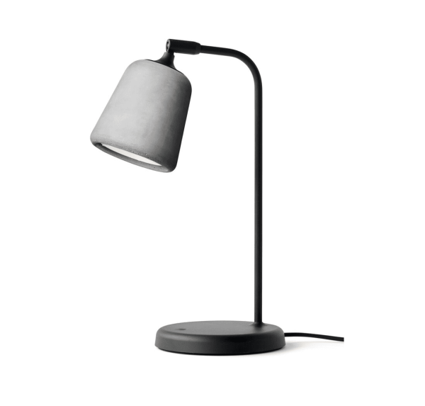 En moderne Material Bordlampe med et buet sort stativ og en grå lampeskærm, isoleret på en hvid baggrund.