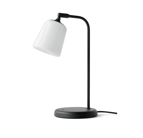 En moderne skrivebordslampe med sort base og buet hals, toppet af en hvid uigennemsigtig lampeskærm, isoleret på en hvid baggrund. NYHED - Materiale Bordlampe
