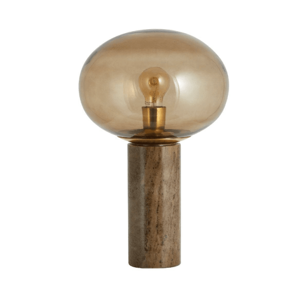 En moderne bordlampe med en stor, rund, uigennemsigtig pære monteret på en cylindrisk marmorbase fra TomorrowsDesign, der udsender en varm, omgivende glød.