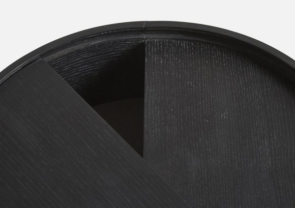 Nærbillede af en WOUD - Arc Sidebord Ø42 med en tekstureret overflade og en synlig søm, set fra en topvinkel, der delvist viser den hule inderside, der er indbegrebet af Tomorrowsdesign.
