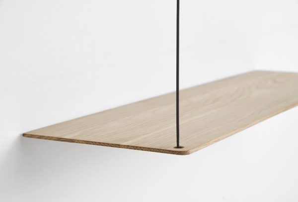 En minimalistisk hylde med en let træplade med en glat finish, understøttet af en slank sort metalstang, monteret på en almindelig hvid væg. Dette design integreres ubesværet i ethvert moderne interiør.