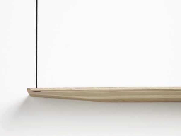 Et minimalistisk billede, der forestiller en slank, lys træhylde monteret på en hvid væg, med en fin skyggelinje, hvor væggen møder hjørnet. Dette stykke viser klassisk interiørdesign.