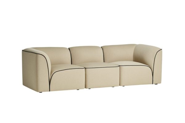 En moderne beige buet sofa med tre sædehynder og sorte rørdetaljer, isoleret på en hvid baggrund, eksemplificerer exceptionelt design.