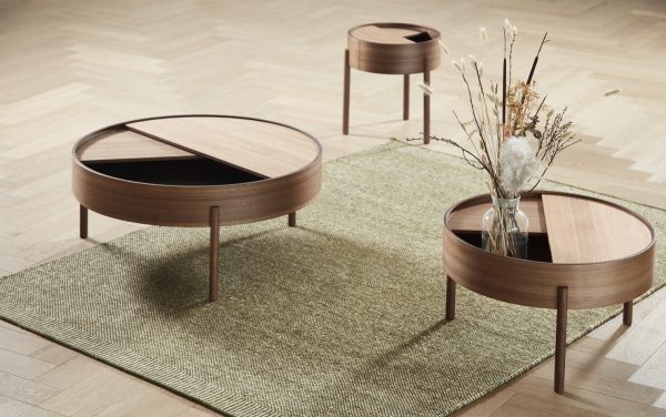 Moderne stue med to runde sofaborde i træ med sorte glasplader og en vase med tørrede blomster på et tekstureret grønt tæppe over et trægulv af Tomorrowsdesign.