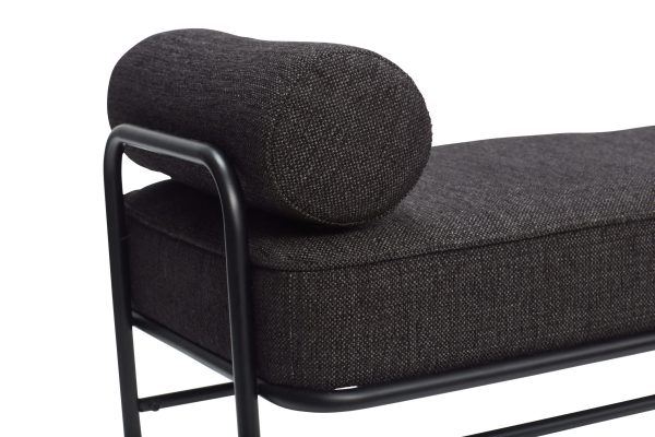 Nærbillede af et moderne sofaarmlæn med en rund, polstret top og en robust sort metalramme, der viser et minimalistisk design med mørkegrå tekstureret polstring. Dette stykke eksemplificerer moderne interiør