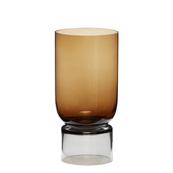 En slank HÜBSCH - Stand Vase Stor glasvase med et glat, tilspidset design, placeret på en reflekterende overflade, der skaber et klart spejlbillede i bunden.