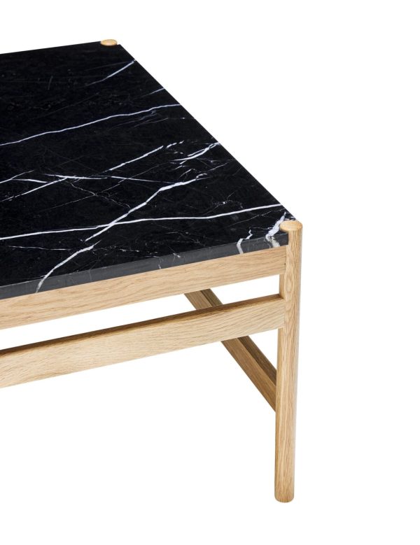 Et moderne sofabord med en sort marmorplade med hvide årer, understøttet af en lys træramme med vinklede ben, isoleret på en hvid baggrund. Dette stykke er en del af Tomorrowsdesign-kollektionen.