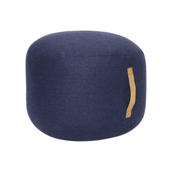 En marineblå stofbetrukket rund skammel med en flad top, med et lille tan tag mærket med "HÜBSCH - Mochi Puf" på siden. baggrunden er almindelig hvid.