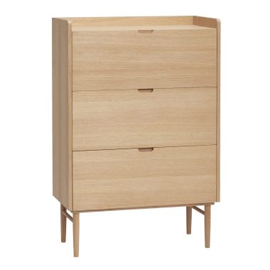 Et moderne design skoskab i egetræ med tre udtræksskuffer og slanke ben, isoleret på en hvid baggrund.