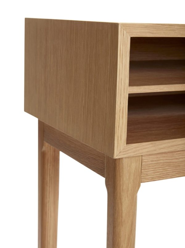 Sidebord i træ med en enkelt åben skuffe, der viser de indvendige rum. Bordet har en glat finish med fire slanke, lodrette ben, fotograferet mod en hvid baggrund af Tomorrowsdesign.