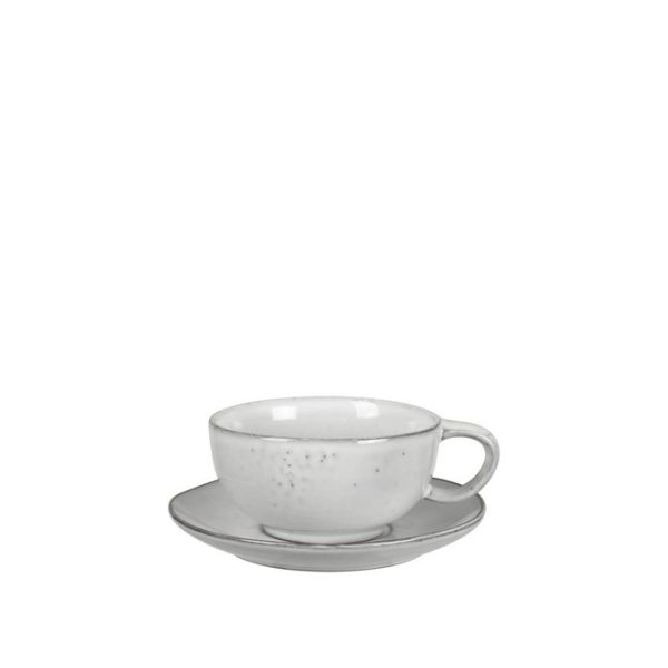 En simpel hvid keramisk tekop sidder på en matchende underkop mod en almindelig hvid baggrund. Sættet, designet af TomorrowsDesign, har et minimalistisk design med subtile pletter på