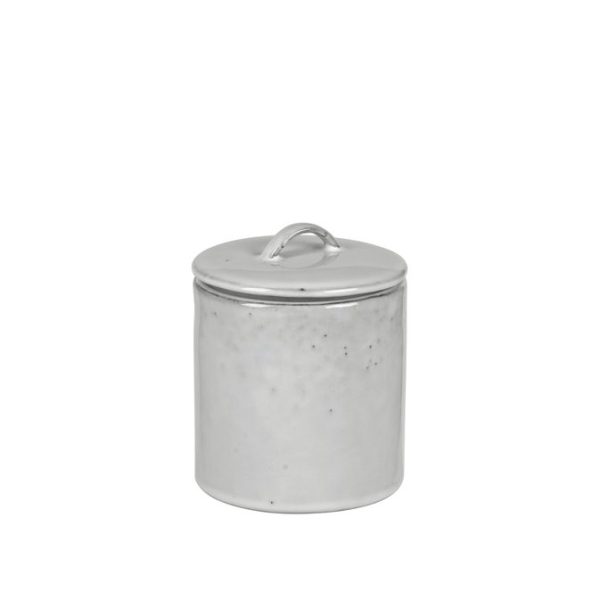 En enkel, slidt BROSTE COPENHAGEN - 'Nordic Sand' Beholder M/Låg med matchende låg, udstillet mod en almindelig hvid baggrund. beholderen viser nogle tegn på ældning og brug, såsom pletter og mindre buler.