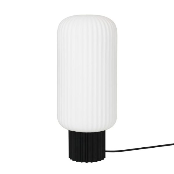 En moderne hvid bordlampe med en rillet cylindrisk skærm monteret på en sort base, med en synlig strømledning og et elegant møblerdesign.
