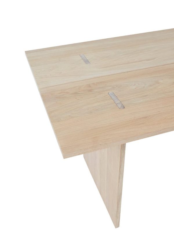 Et nærbillede af et OYOY - Kotai Spisebord L160-hjørne, med et minimalistisk design med synlige årer og to glatte metalliske skuffehåndtag.