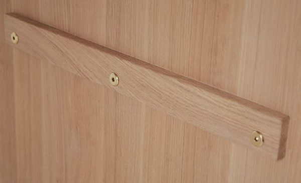 Et nærbillede af en OYOY - Kotai Spisebord L160 med et enkelt, lige træhåndtag fastgjort med to messingskruer. Træet har en let, glat finish og afspejler essensen af Tomorrows design i mø.