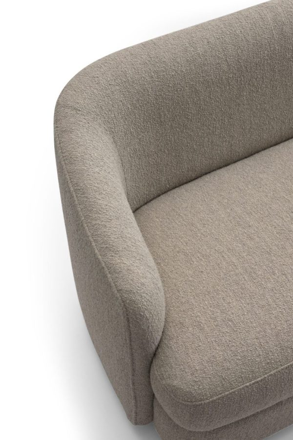 Set ovenfra og ned af et hjørne af en tekstureret grå stofsofa, med detaljer om armlænet og puden på en hvid baggrund, ideel til moderne interiøræstetik.