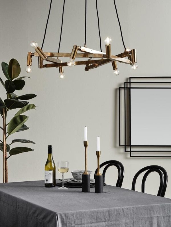 Moderne spisestue med en kunstnerisk lysekrone, en grå dug med en vinflaske, to glas og stearinlys, suppleret med sorte stole og en potteplante. Denne opsætning legemliggør TomorrowsDesigns etos med sit fremadrettede interiør.
