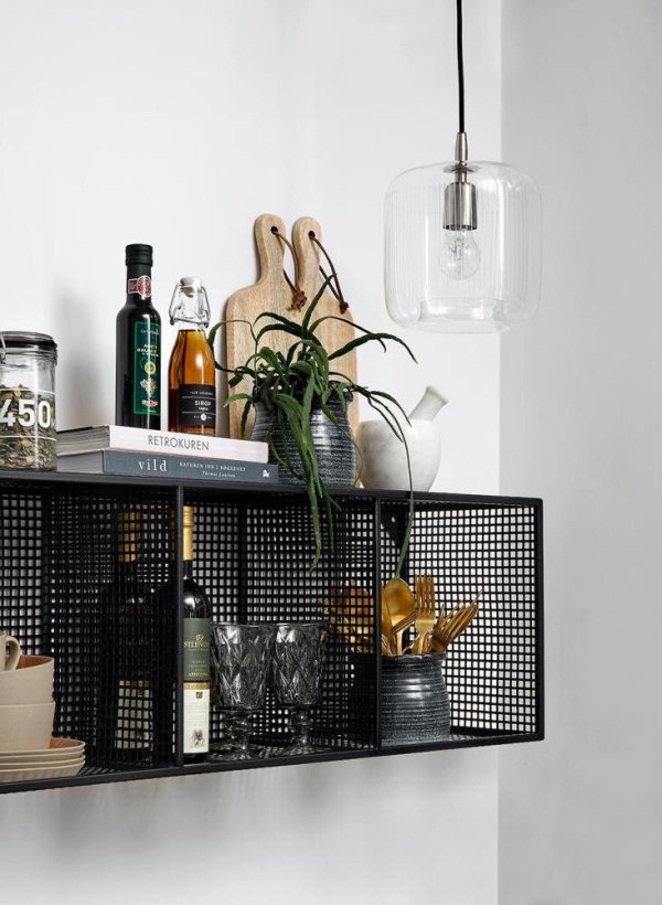 En stilfuld køkkenhylde med diverse ting, herunder bøger, flasker, skærebrætter, en plante og redskaber. En moderne TomorrowsDesign pendel hænger ovenover, med en klar glasskærm.