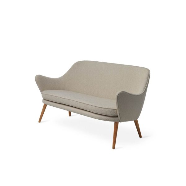 En moderne WARM NORDIC - Dwell Sofa i lys beige med buet ryg og glat stof, stående på tilspidsede træben, isoleret på en hvid baggrund.