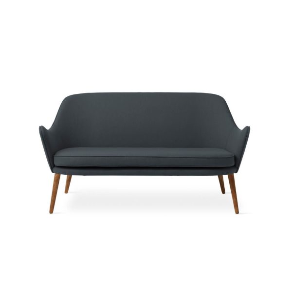 EN VARM NORDISK - Dwell Sofa med et minimalistisk design, med rene linjer, et glat ryglæn og fire træben. Sofaen er centreret mod en almindelig hvid baggrund.