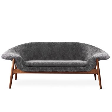 En moderne designmøbler grå stofsofa med glat, buet ryglæn og træramme set forfra på hvid baggrund.