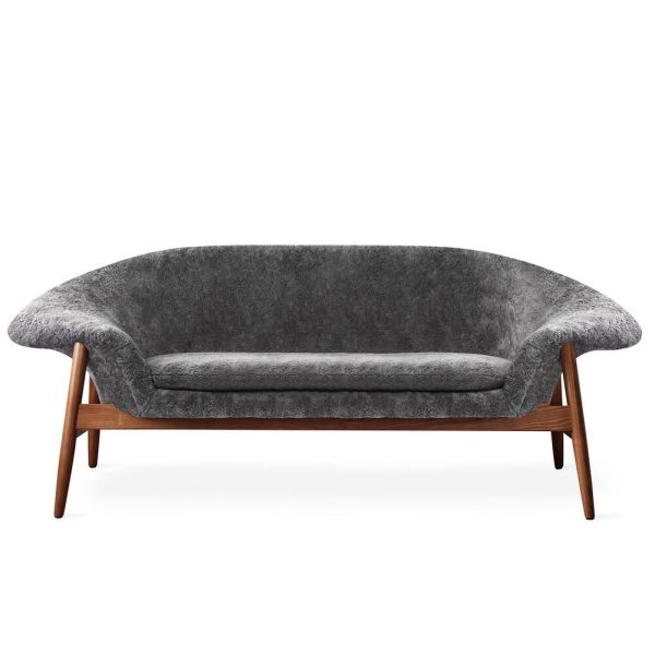 En moderne designmøbler grå stofsofa med glat, buet ryglæn og træramme set forfra på hvid baggrund.