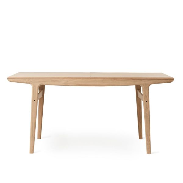 Et spisebord af træ med glat, aflang plade og let vinklede ben, afbilledet mod hvid baggrund. Bordet har en minimalistisk, naturlig designmøbler.