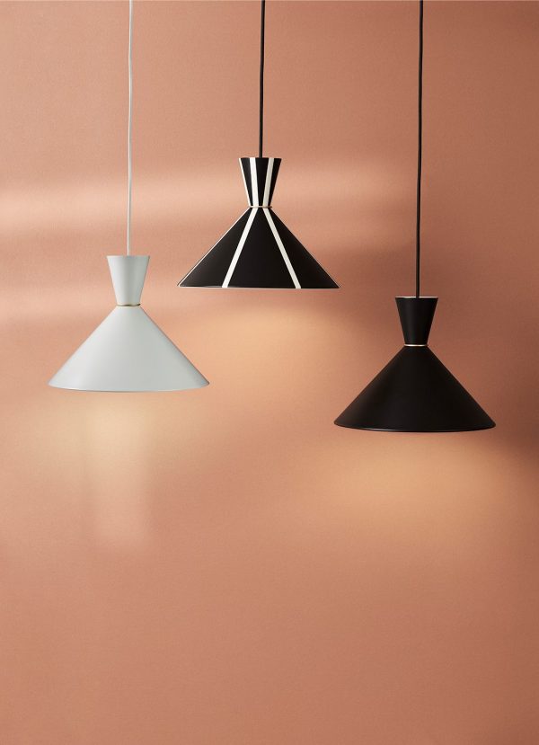 Tre moderne pendellamper i geometriske designs, med hvide, sorte og stribede mønstre fra TomorrowsDesign, hænger mod en varm, ferskenfarvet baggrund.