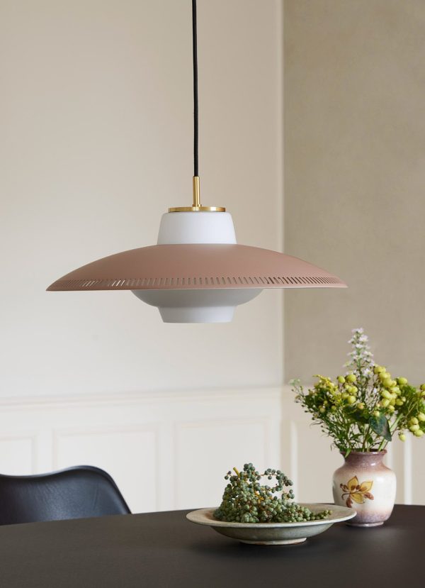 En moderne pendel med en bred, flad skærm hænger over et sort bord prydet med et blomsterarrangement og et lille fad med sukkulenter. Baggrunden er en blød, cremefarvet væg, der viser essensen af TomorrowsDesign.