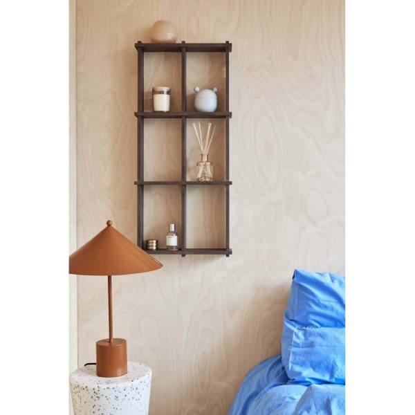 Et hyggeligt soveværelseshjørne med en blå seng med krøllede lagner, en terracottalampe på et plettet sidebord og en træhylde med pynteting mod en lys træpanelvæg. Dette interiørdesign fremhæver funktionalitet og varme.