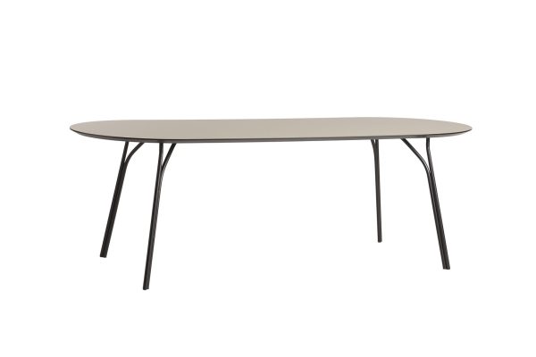 Et minimalistisk ovalt bord med en glat, beige bordplade og fire slanke, sorte metalben, designet som en del af vores eksklusive interiørkollektion, isoleret på en hvid baggrund.