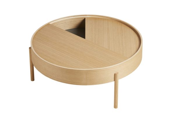 Et moderne sofabord i træ med en rund plade, der er delvist dækket af en drejelig sektion, monteret på tre slanke ben, isoleret på en hvid baggrund. Dette stykke afspejler det seneste inden for design.