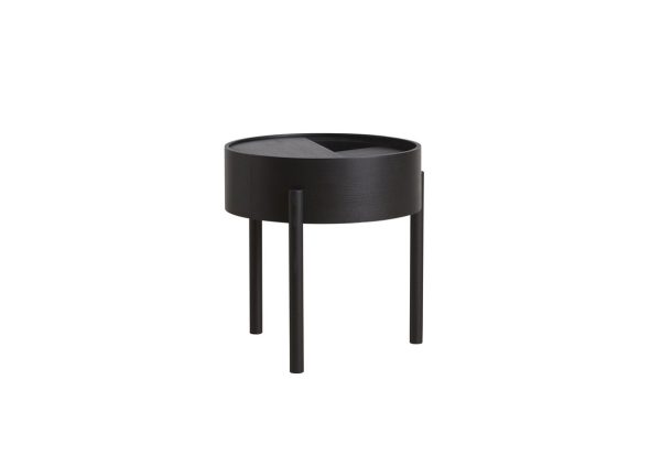 Et moderne, sort cirkulært sidebord med tre slanke ben og en delvist lukket plade, sat mod en almindelig hvid baggrund. Dette stykke eksemplificerer exceptionelt design i moderne interiør æstetik.