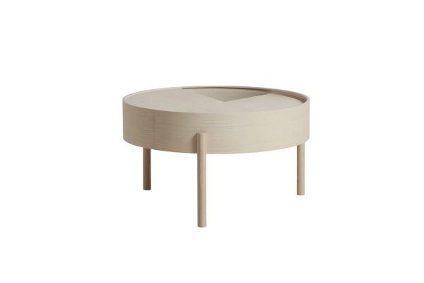 Et moderne rundt, beige sidebord med en forsænket plade og tre slanke træben mod en almindelig hvid baggrund har skandinavisk design.