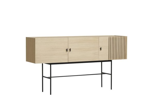 Et moderne skænkskab på slanke sorte ben, med en let træfinish med tre låger, den længst til højre med lodrette lameller. designet er enkelt og elegant, velegnet til moderne interiør. WOUD - Array Skænk.