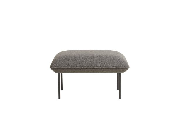 En enkel, rektangulær WOUD - Nakki Puf med gråt polstring og fire slanke, sorte metalben, isoleret på en hvid baggrund.
