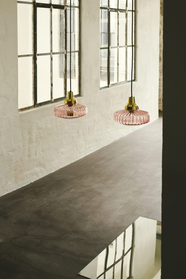 To DESIGN BY US - New Wave Pendel pendellamper hænger over en betondisk med store vinduer i et rum med hvide murstensvægge. det naturlige lys kaster bløde skygger rundt i rummet.