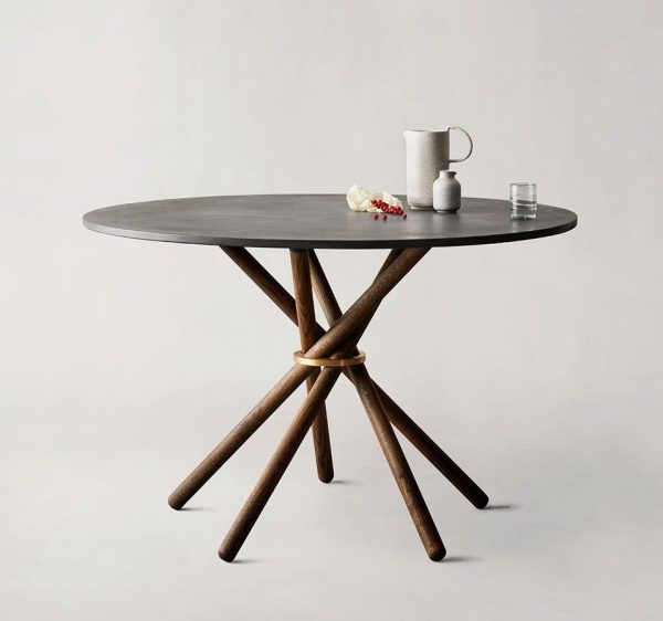 Et rundt, mørkt træbord med et indviklet bunddesign, med en hvid kande, et højt glas vand og en lille tallerken med en croissant, sat på en neutral baggrund. Perfekt til at forbedre ethvert interiør.