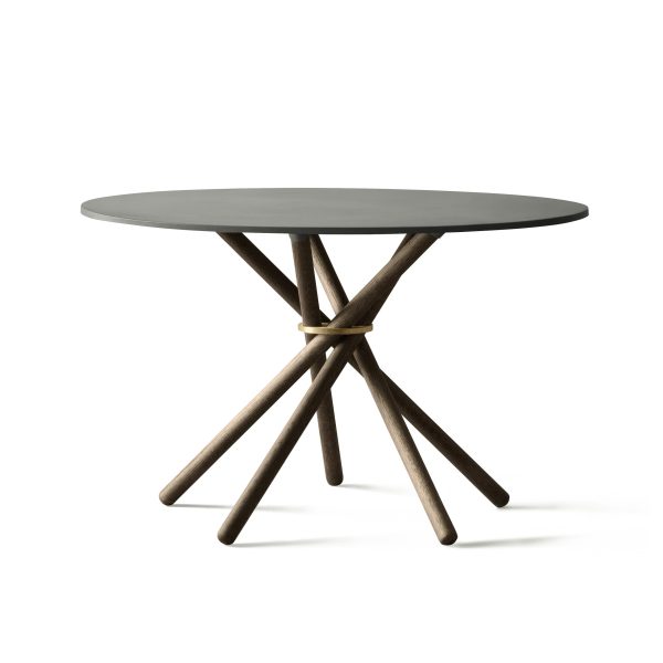 Et moderne rundt bord med en mørkegrå plade og en indviklet bund bestående af flere vinklede træben flettet sammen. Baggrunden er almindelig hvid, hvilket understreger bordets designmøbler.