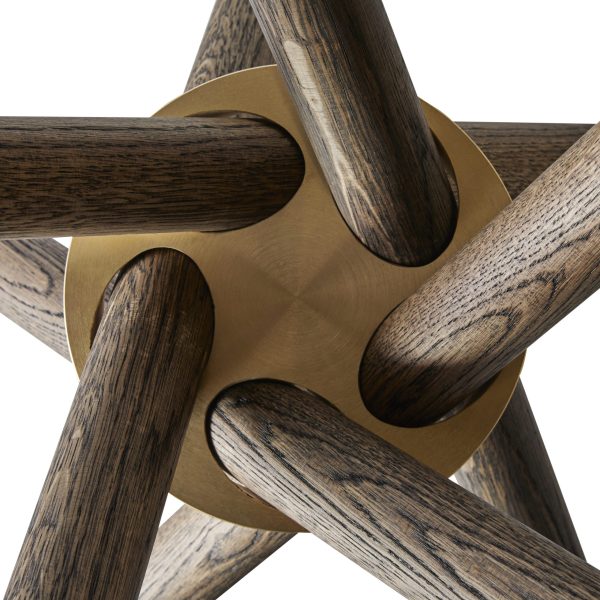 Nærbillede af en EBERHART - Hector Spisebord 120 med mørke træeger, der passer ind i et gyldent metalnav, som viser detaljerede teksturer af træfibre og glat metalfinish.