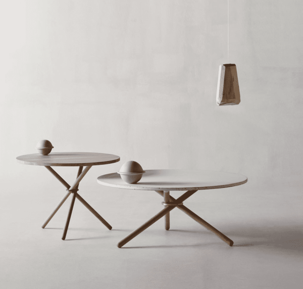 To EBERHART runde sofaborde med træben og et minimalistisk design, det ene mindre og mørkere end det andet. en hængende træ pendel over, i et rum med en lys grå baggrund.