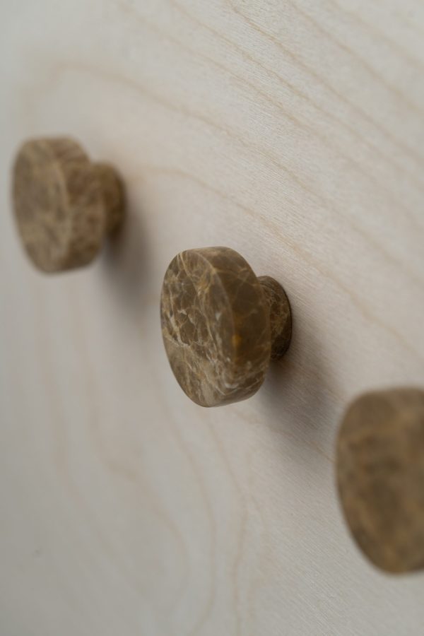 Tre runde, brunlig teksturerede WABI SABI NORDIC - Terra Knage knopper rager ud fra en lys træoverflade, arrangeret diagonalt. fokus er på den nærmeste knap, med de andre lidt slørede i baggrunden.
