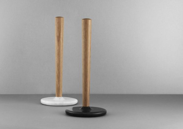 To minimalistiske NORMANN COPENHAGEN - Craft Køkkenrulleholder på en grå baggrund; en med hvid bund, og en med sort bund, begge med høje træstængler.