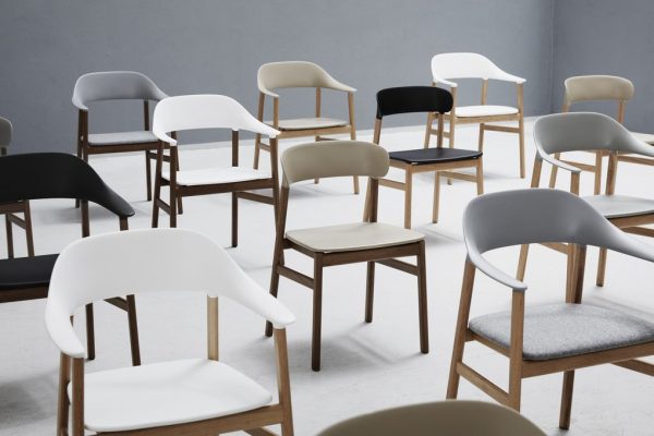 Assorterede NORMANN COPENHAGEN - Herit Spisebordsstol stole i forskellige stilarter og neutrale farver arrangeret tilfældigt i et gråt studierum.