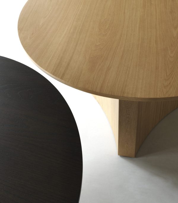 Nærbillede af to runde træborde, et mørkt og et lyst, med kontrasterende træteksturer og -farver, der understreger minimalistisk designmøbler og enkelhed.
