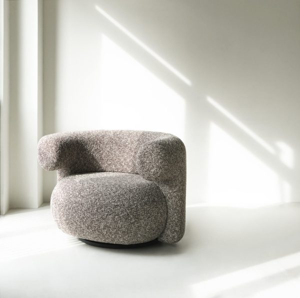 A NORMANN COPENHAGEN - Burra Loungestol M. Drejefunktion med tekstureret polstring i et lyst, solbelyst rum, der kaster geometriske skygger på gulvet.