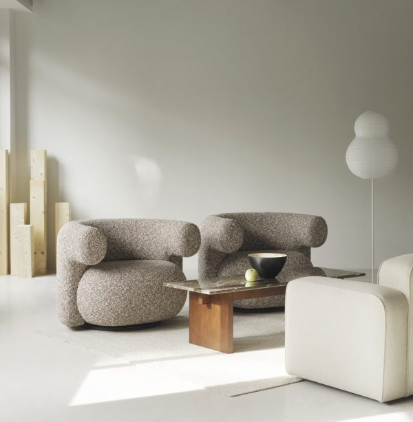 Moderne stue med to NORMANN COPENHAGEN - Burra Loungestol M. Drejefunktion lænestole, et slankt sofabord i træ med frugt og en minimalistisk lampe i et neutralt tonet rum med rigeligt naturligt lys.