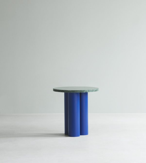 ET NORMANN COPENHAGEN - Dit Bord sidebord med en blå cylindrisk base og en cirkulær grøn glasplade, mod en grå baggrund.