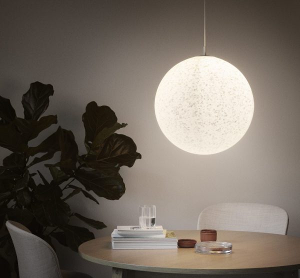 EN NORMANN COPENHAGEN - Pix Pendel Ø45 pendel oplyser en spiseplads med et rundt bord, prydet med bøger, glas og små pyntegenstande, ved siden af en stor, løvrig indendørs plante. stemningen er rolig og moderne.